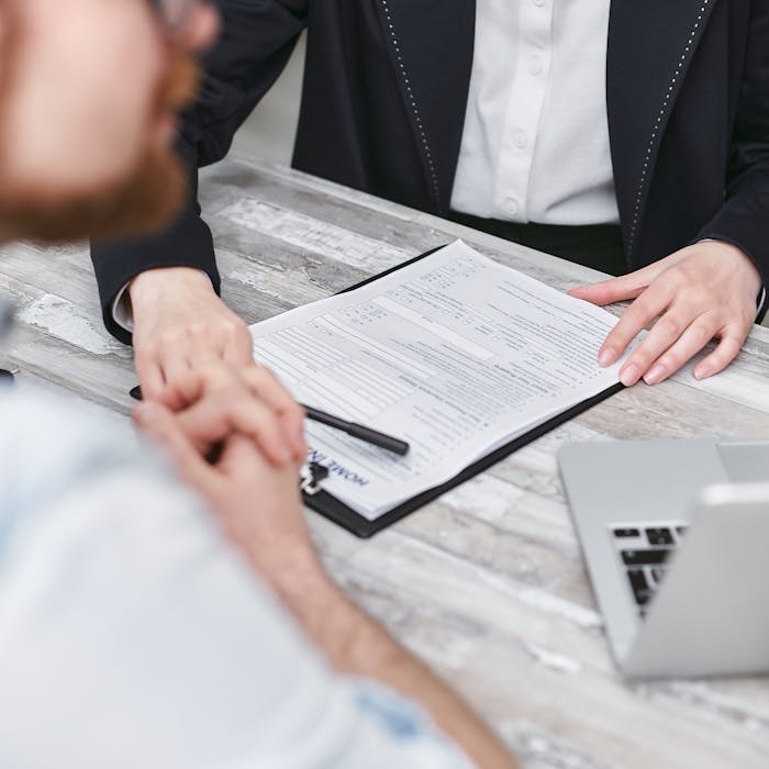 Crafting Captivating Headlines: Your awesome post title goes here Two people in a business meeting reviewing documents on a clipboard.