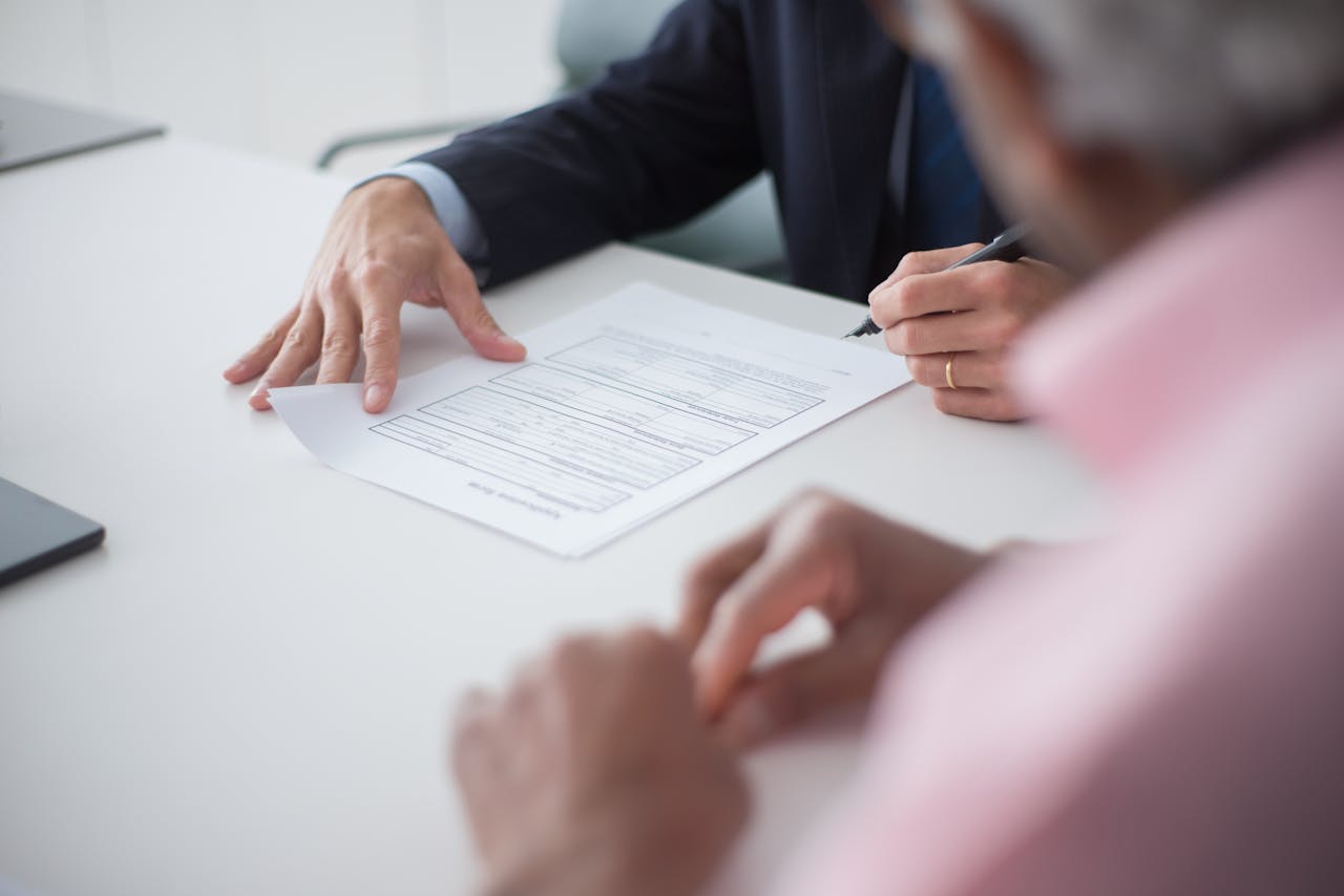 The Art of Drawing Readers In: Your attractive post title goes here Two professionals engaging in a business meeting, signing documents for a consulting agreement.